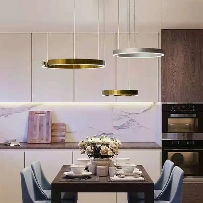 Moderno candeeiro suspenso LED em formato de anel, com intensidade regulável, nas cores dourado e preto, ideal para mesas, salas de jantar, cozinhas e quartos. Design minimalista e elegante. 